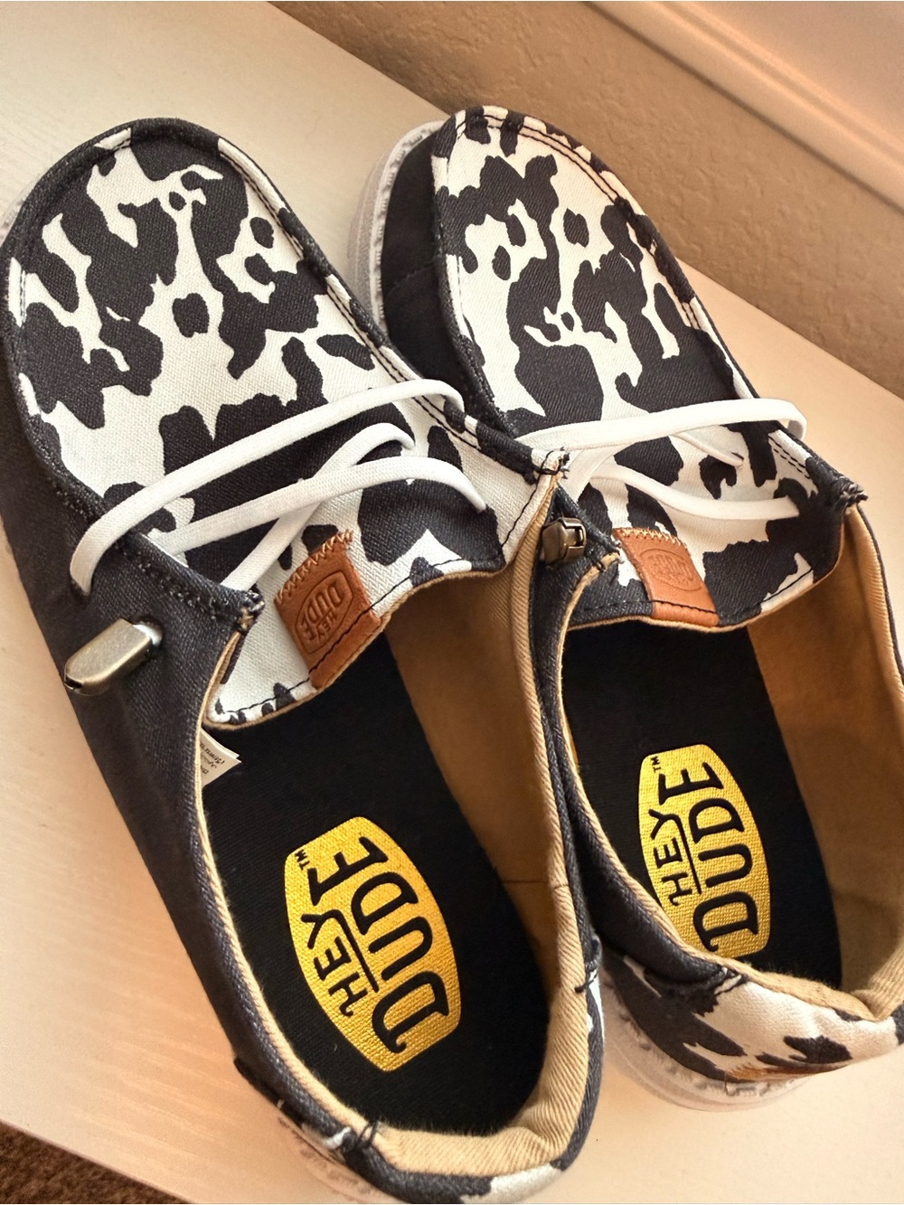 Hey Dude Women’s Cow-Print Slip-On Sneakers in Black & White